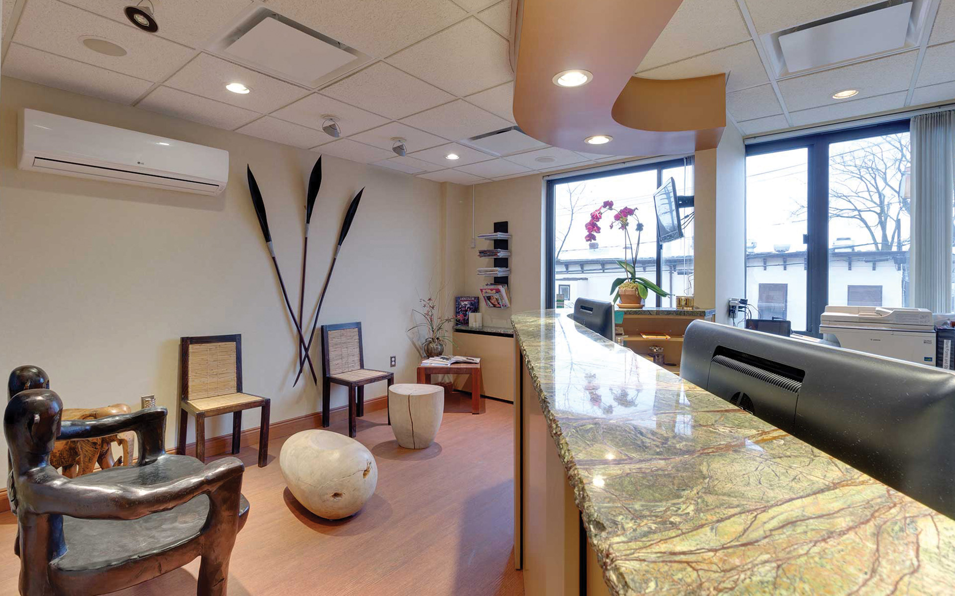 A modern dental practice with a blue and white chair, a dental treatment table, and medical equipment.